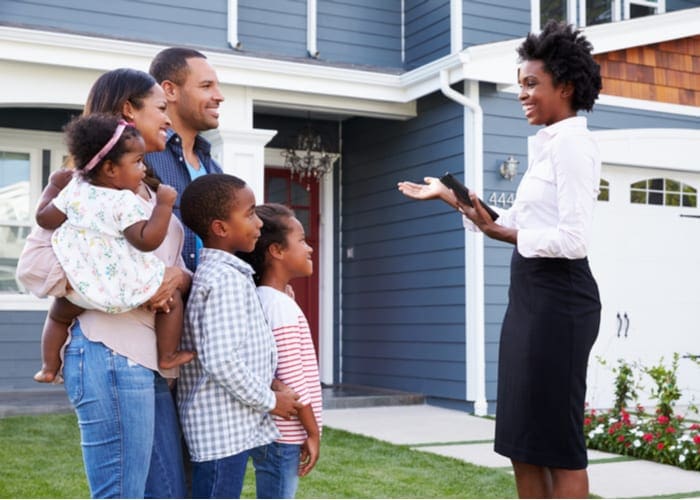 Real estate agent showing a family a house, closer in