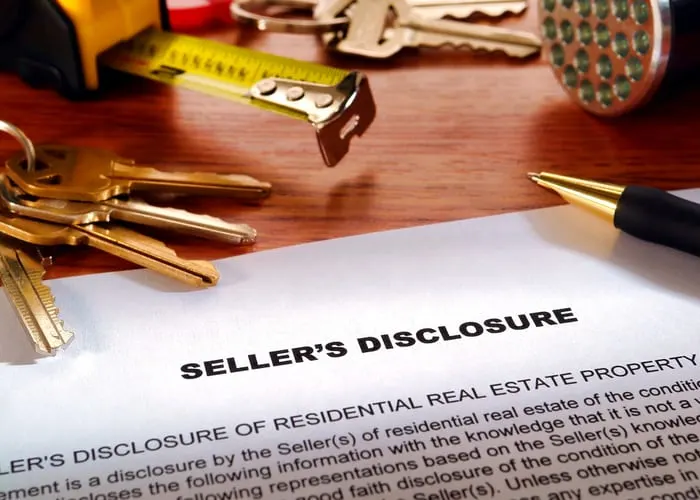 Real estate homeowner seller property disclosure condition statement with house keys and inspection flashlight on a home owner desk (fictitious but authentic language document)