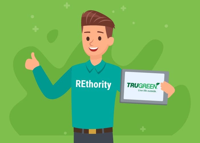 Man in a REthority shirt holding a tablet that has the Trugreen logo on it