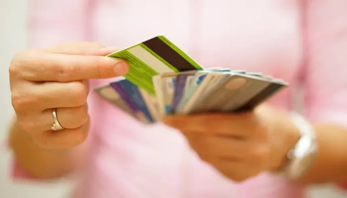 As an image for a piece on fund and grow review, woman choose one credit card from many, concept of credit card debt,