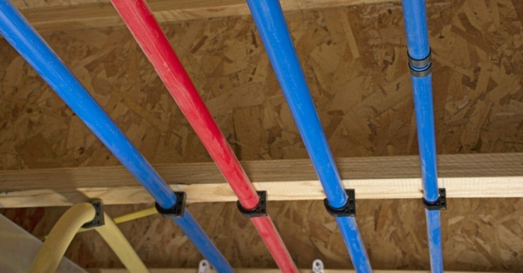 Pex pipe in blue and red attached to ceiling joists