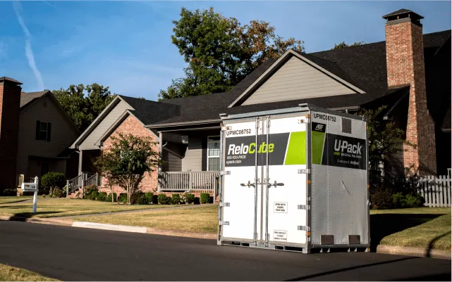A U-Pack pod container sitting outside of a suburban home