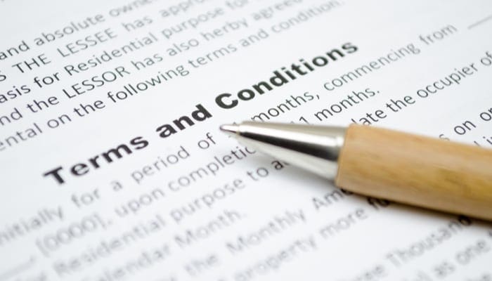 A list of terms and conditions on a contract with a pen sitting on top of the paper as the featured image for a piece on Seller Carryback
