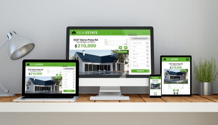 As an image for a piece on real estate branding, A computer, laptop, smartphone and tablet on a desktop workspace with real estate online responsive website on screen. 3d Illustration. All screen graphics are made up.