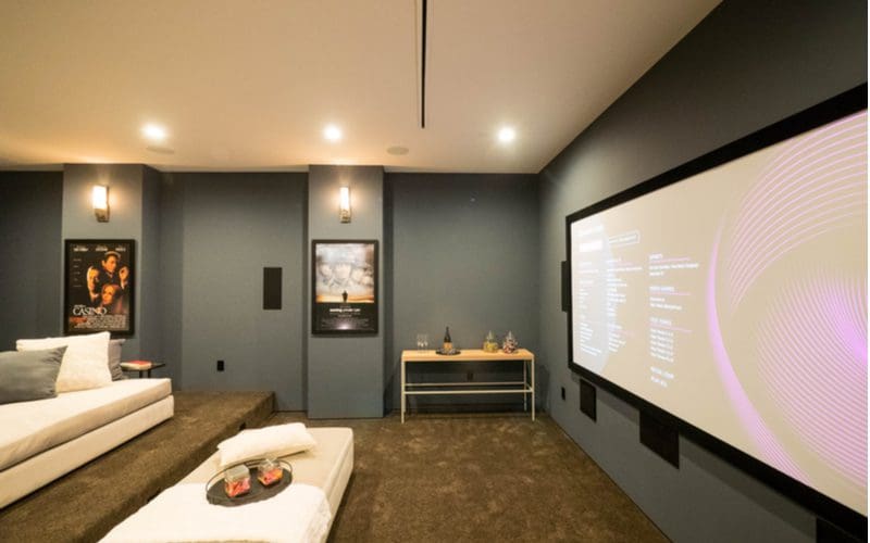 Unfinished basement idea featuring a home movie theatre with a projector on the wall