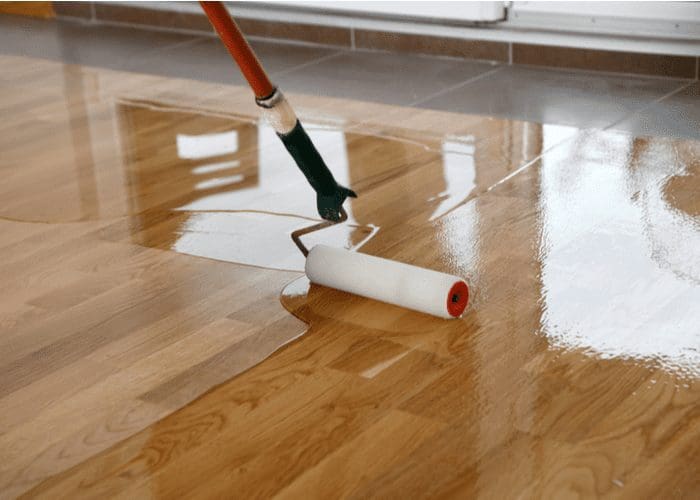 Varnish or polyurethane being applied to wood flooring for a piece on how to waterproof wood