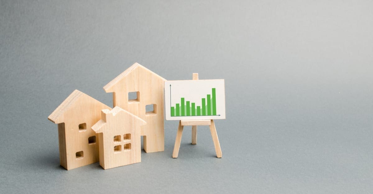 Wooden houses with a stand of graphics and information. Growing demand for housing and real estate. growth of the city and its population. Investments. rising prices for housing. Selective focus