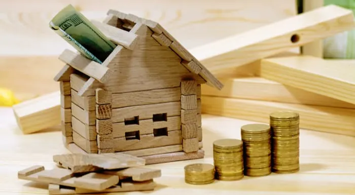 Wooden house block with coins. (finance, property and house loan concept). Project cozy house. Money for the building and details of the new building. Buying a new home.