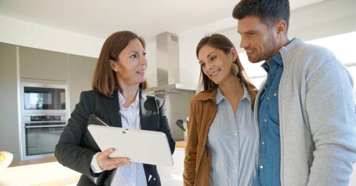Couple with real-estate agent visiting house for sale