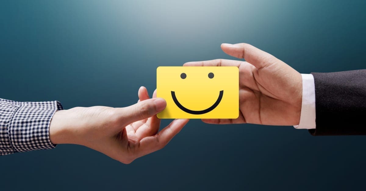 Customer Experience Concept, Happy Client Woman giving a Feedback with Happy Smiley Face Card into a Hand of Businessman