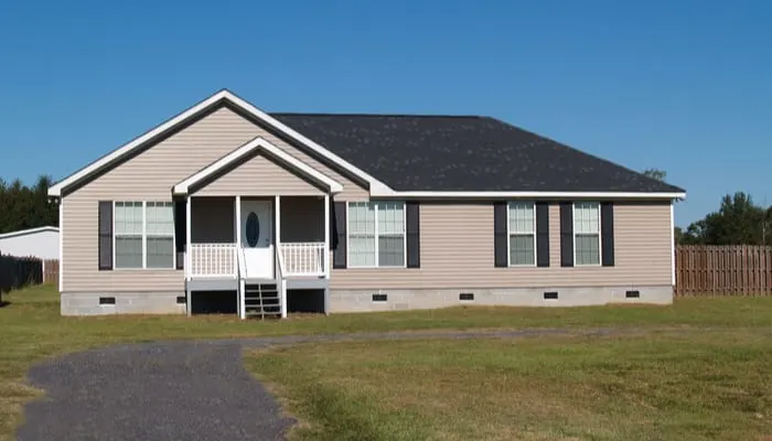 Small low income manufactured home with a covered porch and vinyl siding for a piece on mobile home investing