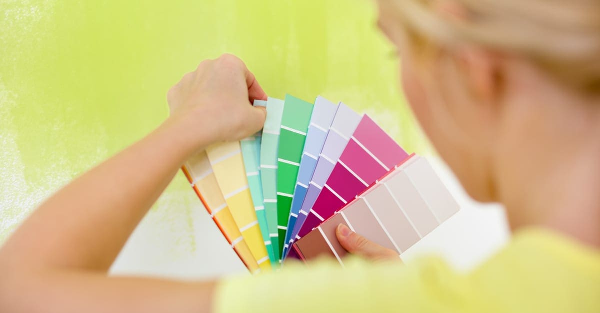 Woman choosing color for painting wall as the featured image for a piece on latex paint