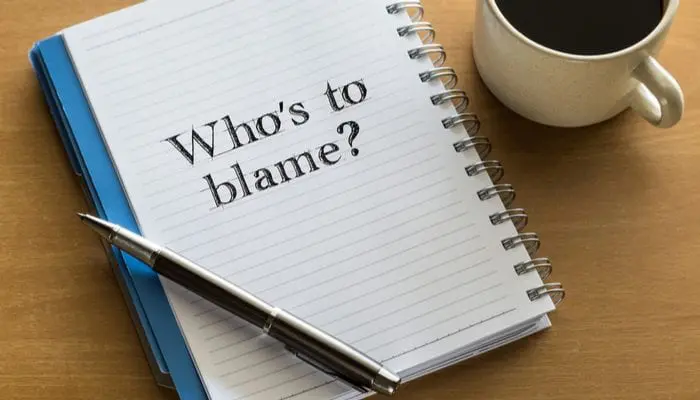Who is to blame? responsiblity concept - handwriting on a notebook with cup of coffee