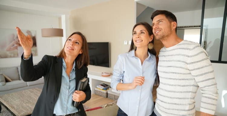 Couple with real-estate agent visiting house for sale as the featured image for a piece on Real Estate Jobs