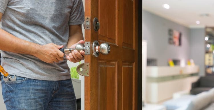 As a featured image for a piece on Locksmiths Near Me, photo of a locksmith open the wood door to blur living room - can use to display or montage on produc