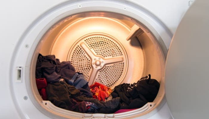 As an image for a piece on a dryer that won't start,Interior view of typical modern domestic tumble dryer with laundry in it.