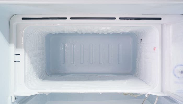 empty freezer of a refrigerator - Ice buildup on the inside of a freezer walls.