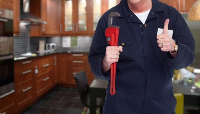 Plumber with a wrench giving the thumbs up