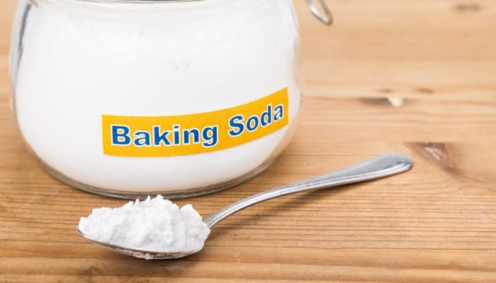 Jar and spoonful of baking soda for multiple holistic usages including using it to get slime out of carpet