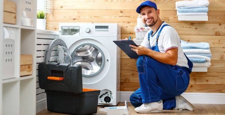 As an image for a piece on Appliance Repair Near Me, working man plumber repairs a washing machine in laundry