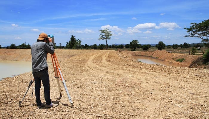 Land surveyors using camera on construction site