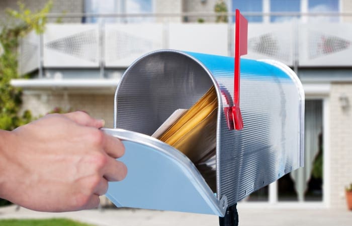 Close-up Of A Person Hand Checking Mailbox Outside The House