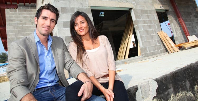 As an image for a piece on buyers lists, Happy couple sitting in front of house under construction