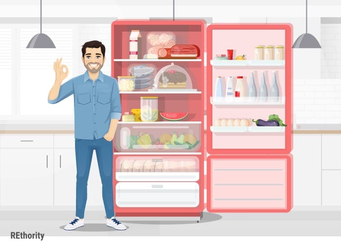 A guy in a REthority shirt standing in front of an open red refrigerator giving the thumbs up
