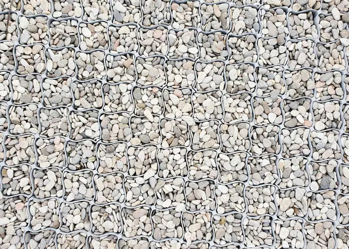 Seamless plain white gravel texture with plastic garden grate background. Top view