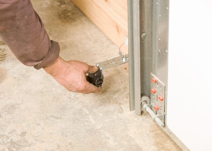 A man aligning garage door sensor with his hand