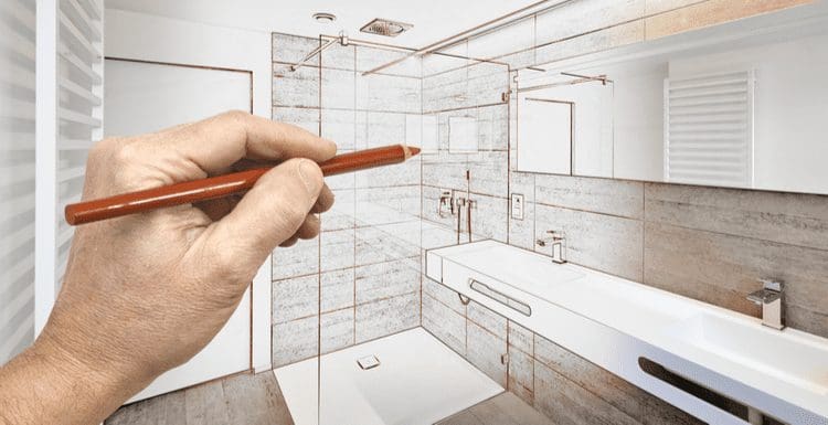 Guy with a red pencil draws a sketch of a bathroom for a piece on how much does it cost to add a bathroom
