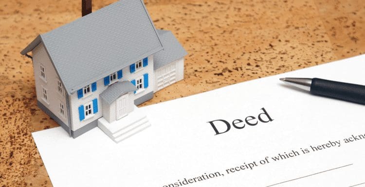 Featured image showing you how to get a copy of your deed represented by a small toy house and a deed printed on a paper
