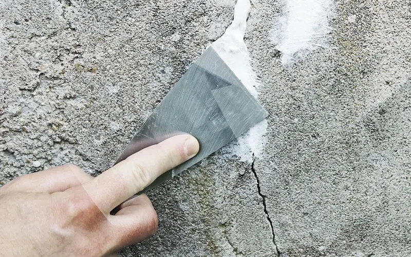 Fill cracks with the caulk, then use the putty knife to smooth it