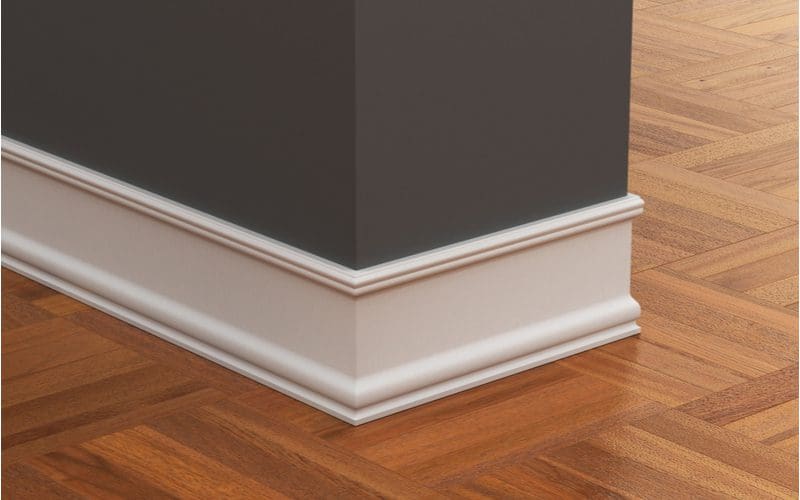 Types of crown molding featuring a baseboard below a dark grey wall