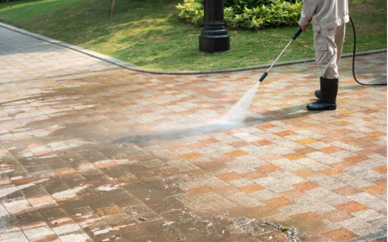 Easy curb appeal idea of power washing a sidewalk to get the grime off the brick pavers