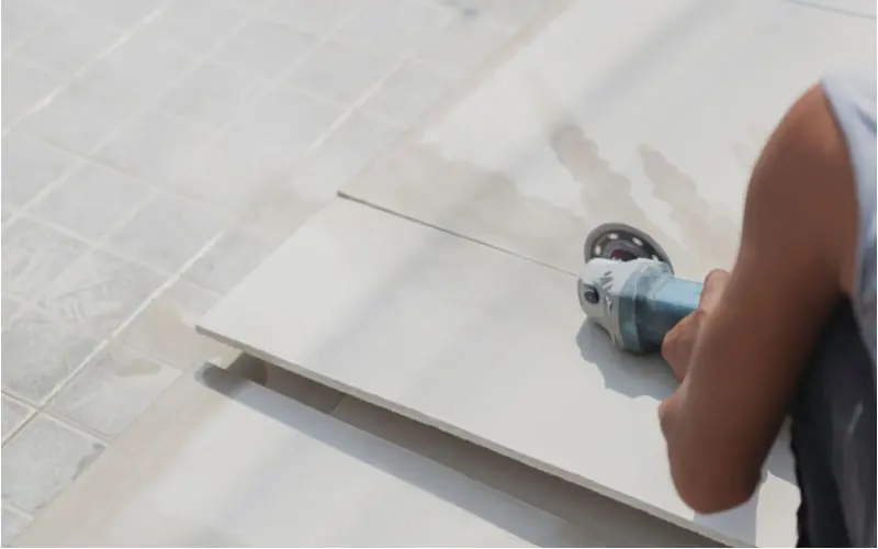 To illustrate how to cut cement board with a circular saw, a guy in a cutoff shirt doing this