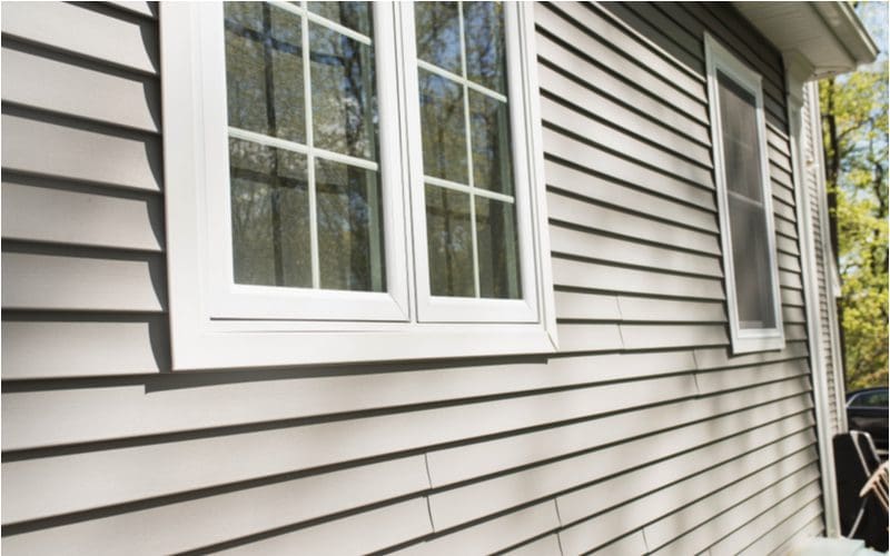 Vinyl siding next to vinyl replacement windows in an exterior shot showing how easily it can improve the look of the home
