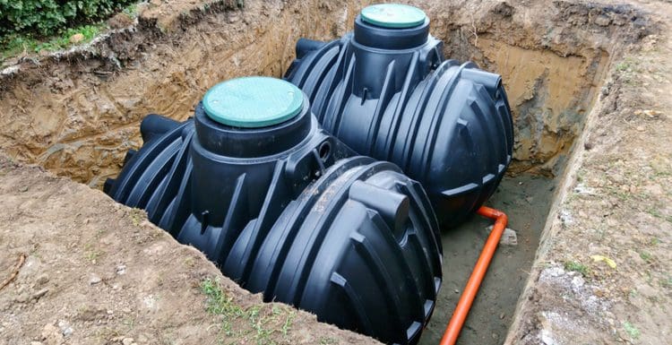 As a featured image for a piece on septic system cost, two tanks sitting in a pit that has yet to be covered