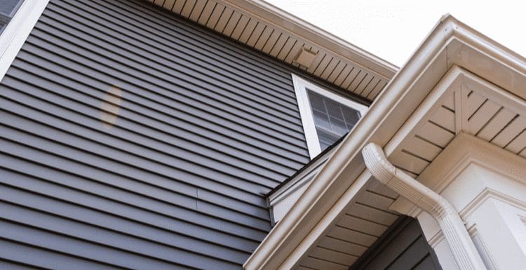 Different types of vinyl siding on a house in grey and off-white colors