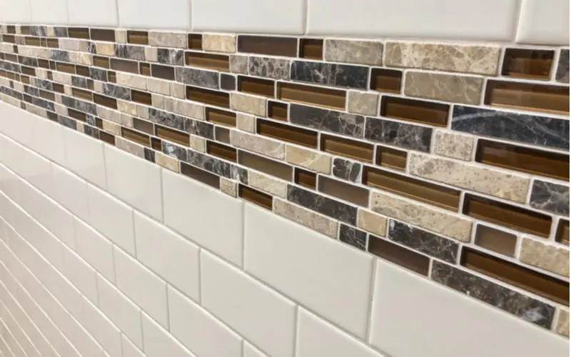 White subway tile mixed with glass subway tile for an explainer on sanded vs unsanded grout