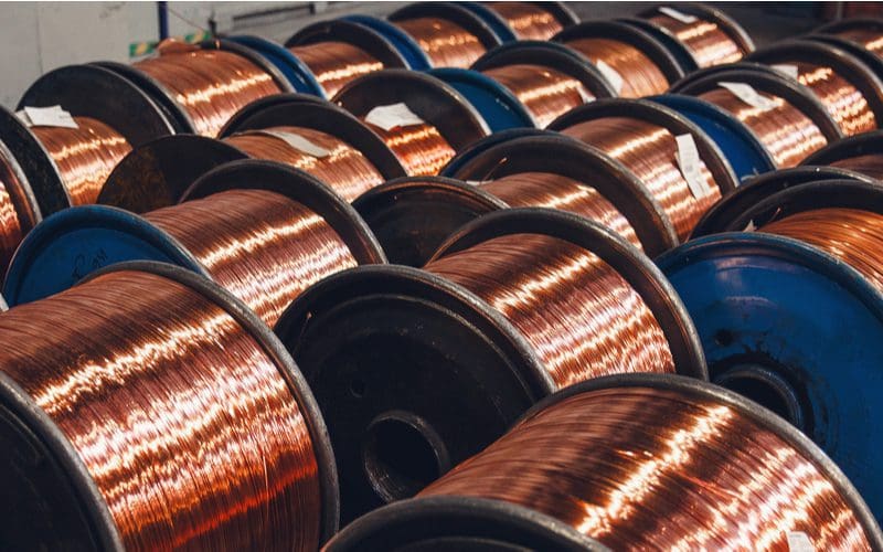 Image of copper wire and bronze cable spooled on a factory floor for a piece on what size wire for 200 amp service