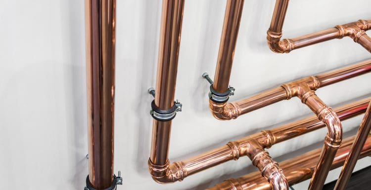 To symbolize air in water lines, close-up of shiny copper water pipes in a house