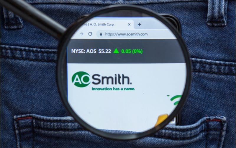 AO Smith logo below a stock ticker as viewed through a magnifying glass to symbolize the best water heater brands