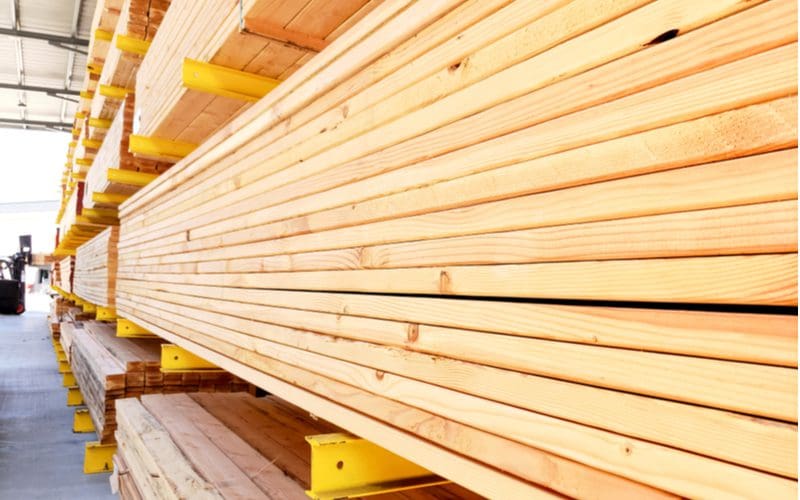 Stack of pressure treated lumber lying in rows in a hardware store ready to be stained
