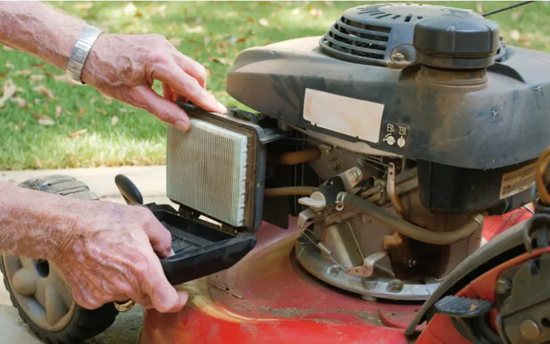 Man replacing his lawn mower air filter because it won't stay running