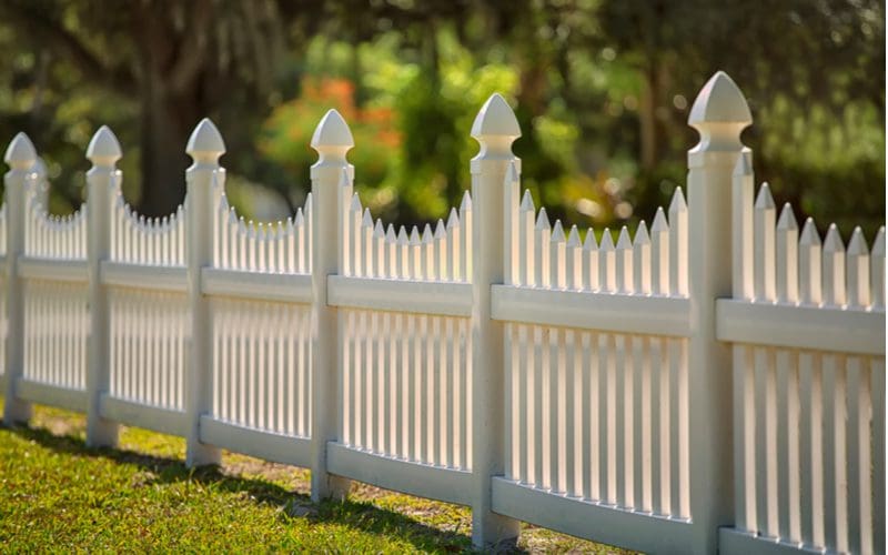 White scalloped vinyl picket fence for a piece on vinyl fence cost