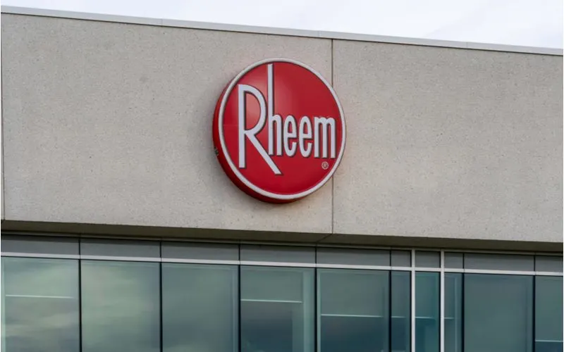 Rheem (one of the top water heater brands) on the outside of a stucco and glass building on a cloudy day