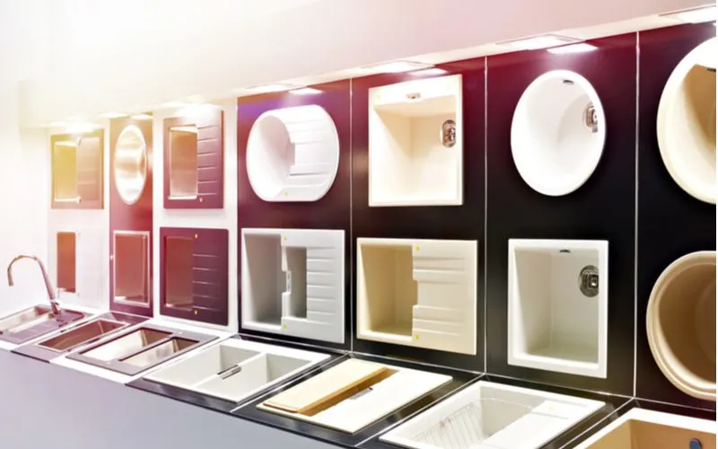 Various types of kitchen sinks in all standard dimensions mounted on a wall in a store