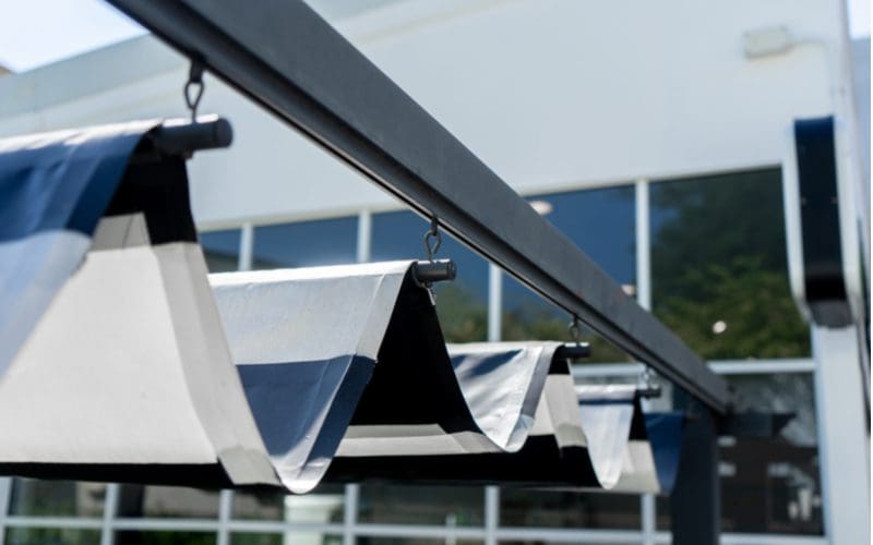 Retractable awning patio shade idea with rollers and clips on a metal track