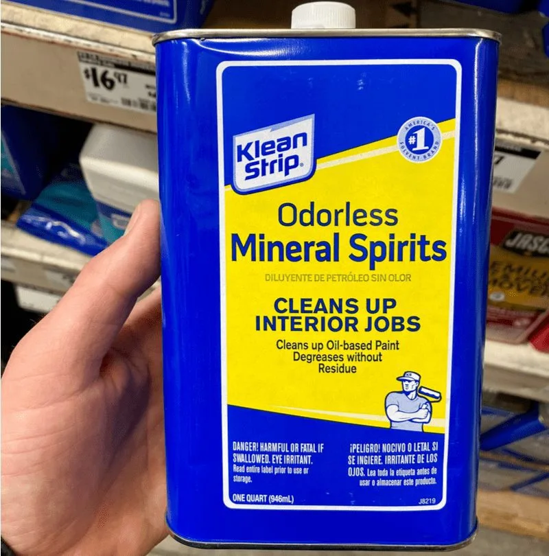 Person holding a mineral spirits can in their left hand for a piece on removing paint from metal